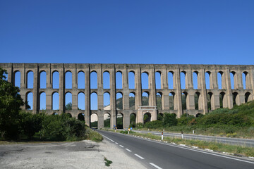 Fototapeta na wymiar Caserta province, Italy. The arched aqueduct built in the 18th century to bring water to the gardens of the royal palace of Caserta.