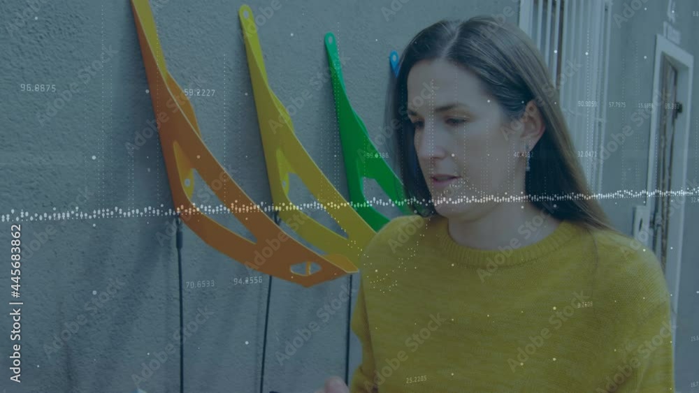 Poster multiple changing numbers and statistical graphs against caucasian woman using smartphone