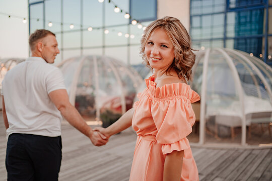 a man and a woman in love walk to a rooftop cafe on a date.