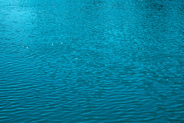 Blue water background. The calm surface of the sea. Ocean. Natural abstract background. Film grain and noise.