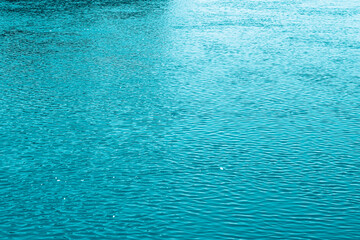 Blue water background. The calm surface of the sea. Ocean. Natural abstract background. Film grain and noise.