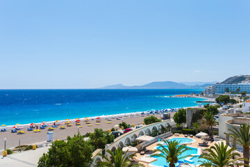 Colorful umbrellas and sunbeds on an empty beach resort - vacation concept on Greece islands in...