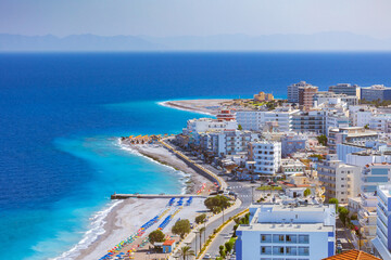 Colorful umbrellas and sunbeds on an empty beach resort - vacation concept on Greece islands in Aegean and Mediterranean seas. Elli Beach in Rhodes city.