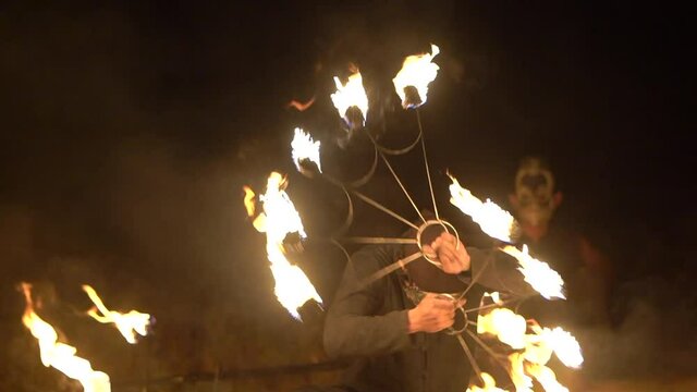 Masked man performs a fire show at night, thailand