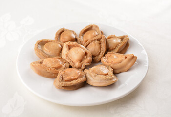 raw 10 head fresh abalone in slice and whole piece in white background asian seafood halal sashimi menu