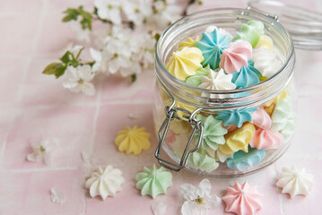 Obraz na płótnie Canvas Small colorful meringues in the glass jar