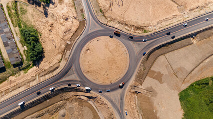 Top down aerial view of a traffic roundabout. Roundabout traffic of cars and trucks on the circle...
