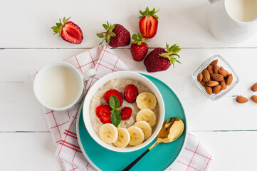 Oatmeal muesli cereal in a bowl with strawberries, banana and almonds. Healthy breakfast.