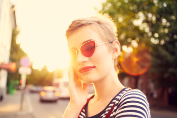 woman in sunglasses with short hair outdoors romance posing