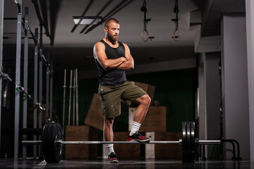 Athlete preparing for weightlifting. Muscular man posing in fitness studio