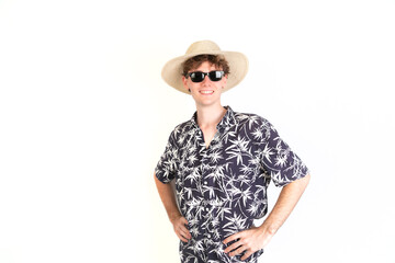 Teenager ready to go to the beach with a hat, sunglasses and a palm trees shirt. portrait, white background, 18-20 years old. White european guy.