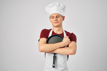 chef in uniform Frying pan in the hands of a professional restaurant kitchen