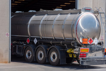 Fototapeta na wymiar Tank truck with dangerous goods due to flammable and toxic liquids entering an industrial warehouse.