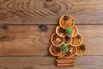 Christmas tree made of dried oranges, cinnamon and star anise on wooden background. copy space for text