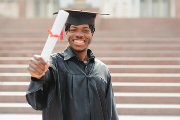 happy african american male college graduate at ceremony