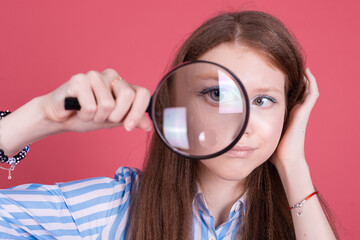 Little kid girl 13 years old in blue dress isolated on pink background  magnifier unhappy sad