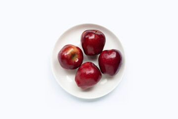 Fresh red apples in white plate on white background. Top view