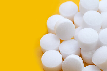 Naphthalene mothballs on yellow backgrond.