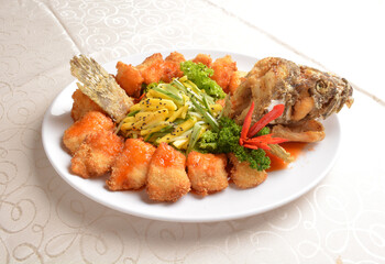 deep fried whole grouper fish seafood with sweet and sour sauce & mango salad in the middle asian halal menu