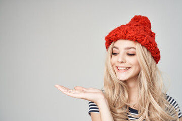 cheerful blonde in a red hat gesturing with her hands emotions