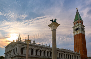 Fototapeta na wymiar Icons of Venice, Italy: St Mark lion and St Theodore columns in piazzetta on St Mark square. Campanile of St Mark and Biblioteca Marciana.