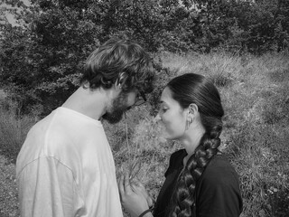 portrait of couple of friends in the country playing with dandelion