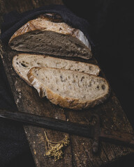 Sliced sourdough bread on a dark wooden surface. Handmade,  according to a traditional Italian...
