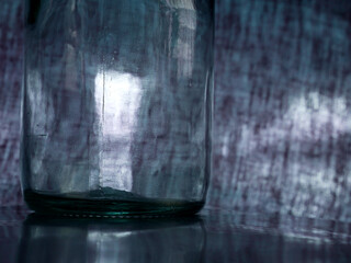 transparent glass bottle presented on gray background with flash light reflection.
