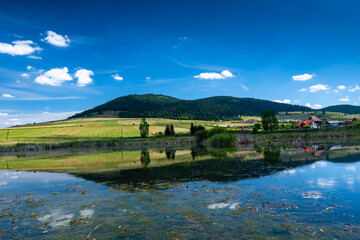 Fototapeta premium Sumuleu mountain reflecting in a small pond in Miercurea Ciuc, Romania, one of the most visited places by pilgrims in Eastern Europe.