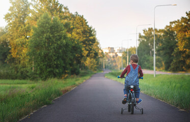 boy rides a bike on the road on a sunny day