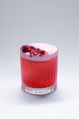 clover club cocktail drink with raspberry and rose petal on white background