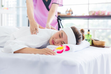 Obraz na płótnie Canvas Young happy woman relaxing in spa salon. Young woman in spa salon lying on the massage desks.