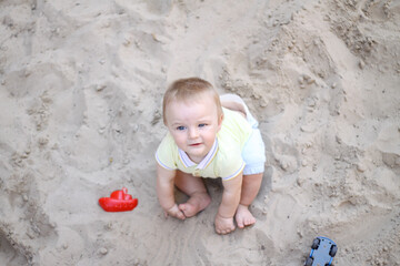 little boy playing in the sand. baby plays with sand. Summer rest. Sun, sea, beach, sand. Rest, childhood.