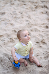 little boy playing in the sand. baby plays with sand. Summer rest. Sun, sea, beach, sand. Rest, childhood.