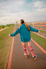 Fototapeta na wymiar mujer joven hermosa con ante ojos patinando al aire libre con sus patines , usa unas medias altas de colores 