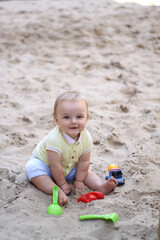 little boy playing in the sand. baby plays with sand. Summer rest. Sun, sea, beach, sand. Rest, childhood.