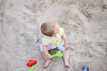 little boy playing in the sand. baby plays with sand. Summer rest. Sun, sea, beach, sand. Rest, childhood.