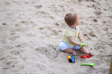 little boy playing in the sand. baby plays with sand. Summer rest. Sun, sea, beach, sand. Rest, childhood.