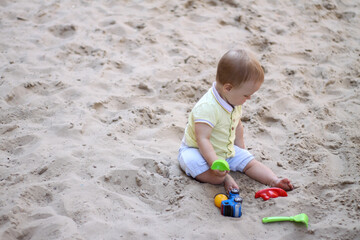 little boy playing in the sand. baby plays with sand. Summer rest. Sun, sea, beach, sand. Rest, childhood.