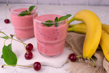 Fresh cherry and banana smoothies on a white plate.