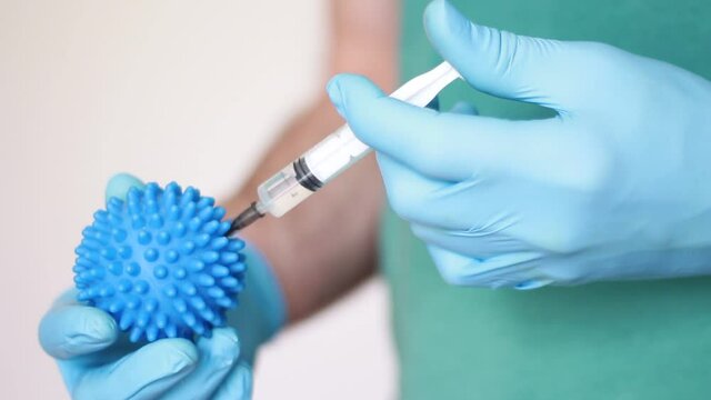hand making injection into blue ball