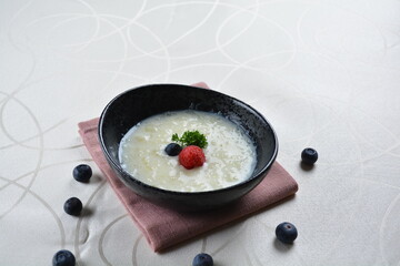 luxury chilled sweet coconut fruit cereal puree with blueberry in black bowl and pink table cloth halal dessert menu