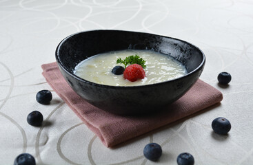 luxury chilled sweet coconut fruit cereal puree with blueberry in black bowl and pink table cloth halal dessert menu