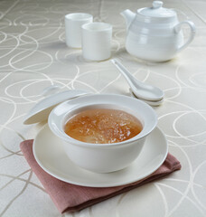 luxury chilled sweet fresh bird nest soup with almond paste and peach resin in bowl and pink table cloth halal healthy dessert menu