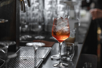 Bartender making aperol spritz summer cocktail in big wine glass