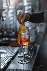 Bartender making aperol spritz summer cocktail in big wine glass