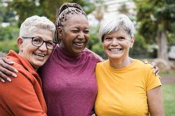 Multiracial senior women having fun together after sport workout outdoor - Focus on left female face