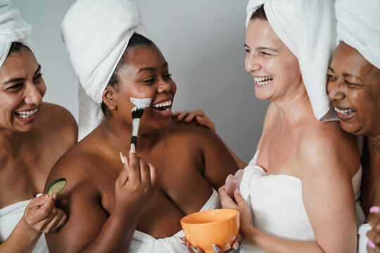 Multigenerational women having fun applying face beauty mask with cucumbers on their face - Skin care therapy - Focus on african girl face