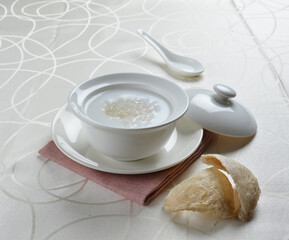 luxury chilled sweet fresh bird nest soup with almond paste and peach resin in bowl and pink table cloth halal healthy dessert menu