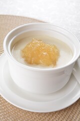 luxury chilled sweet fresh bird nest soup with almond paste and peach resin in bowl and pink table cloth halal healthy dessert menu